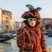 Colorful Venetian masks and costumes at Venice Carnival in St. Mark’s Square, Italy